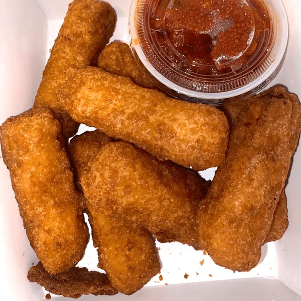 Golden-brown mozzarella sticks with a side of red marinara sauce in a white container.